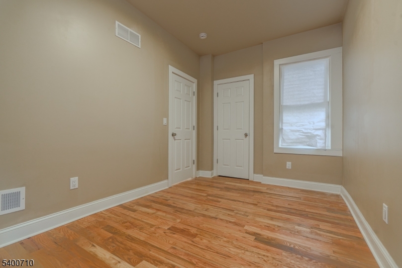 882 South 14th Street, Unit 1 Newark, NJ 07108 - Photo 7 of 17 a view of an empty room with wooden floor and a window