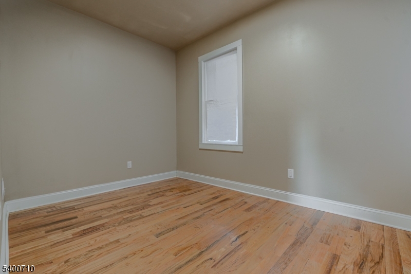 882 South 14th Street, Unit 1 Newark, NJ 07108 - Photo 8 of 17 a view of an empty room with wooden floor and a window