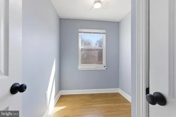 a view of an empty room with wooden floor and windows