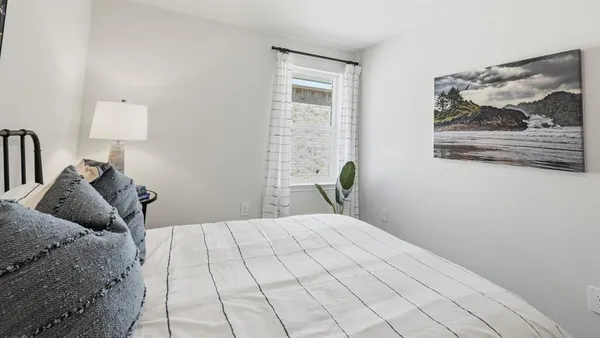 a bedroom with a bed and a painting on the wall