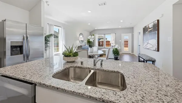 a kitchen with granite countertop a sink and a refrigerator