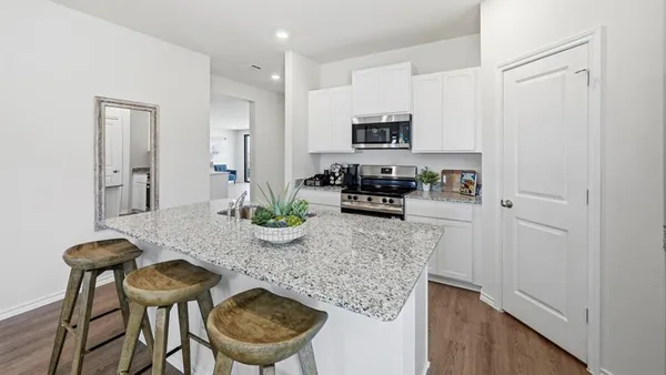 a view of a kitchen area with furniture and wooden floor