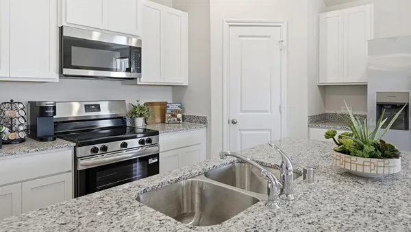 a kitchen with a stove a microwave and cabinets