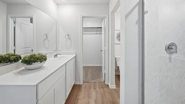 a bathroom with a sink and mirror with shower