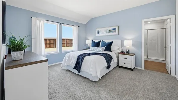 a bedroom with a bed and a potted plant