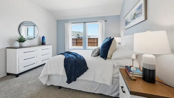 a bedroom with a large bed and a flat tv screen on dresser
