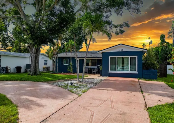 a front view of a house with a yard and potted plants