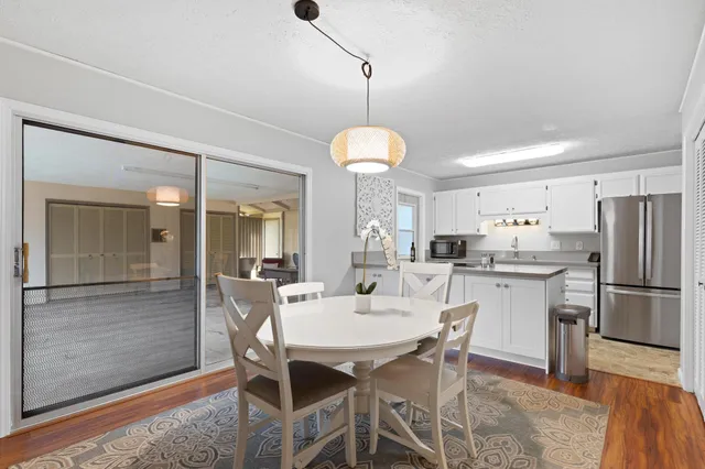 a kitchen with a dining table chairs stainless steel appliances and cabinets