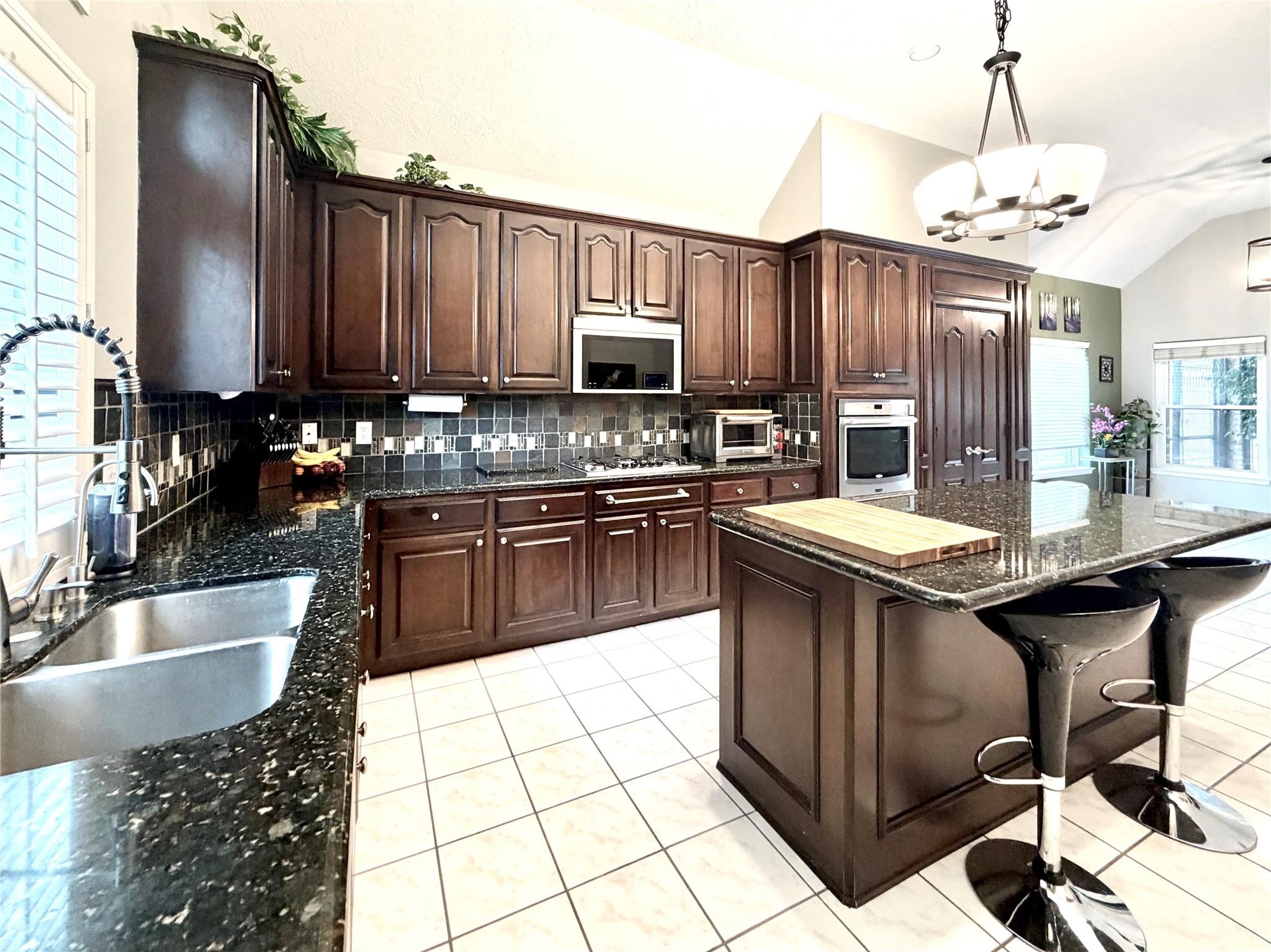 24818 Haverford Road Spring, TX 77389 - Photo 22 of 45 Gorgeous Island Kitchen with Breakfast Counter, S/S Appliances, Granite Counters, and Raised Panel Cabinet Door.