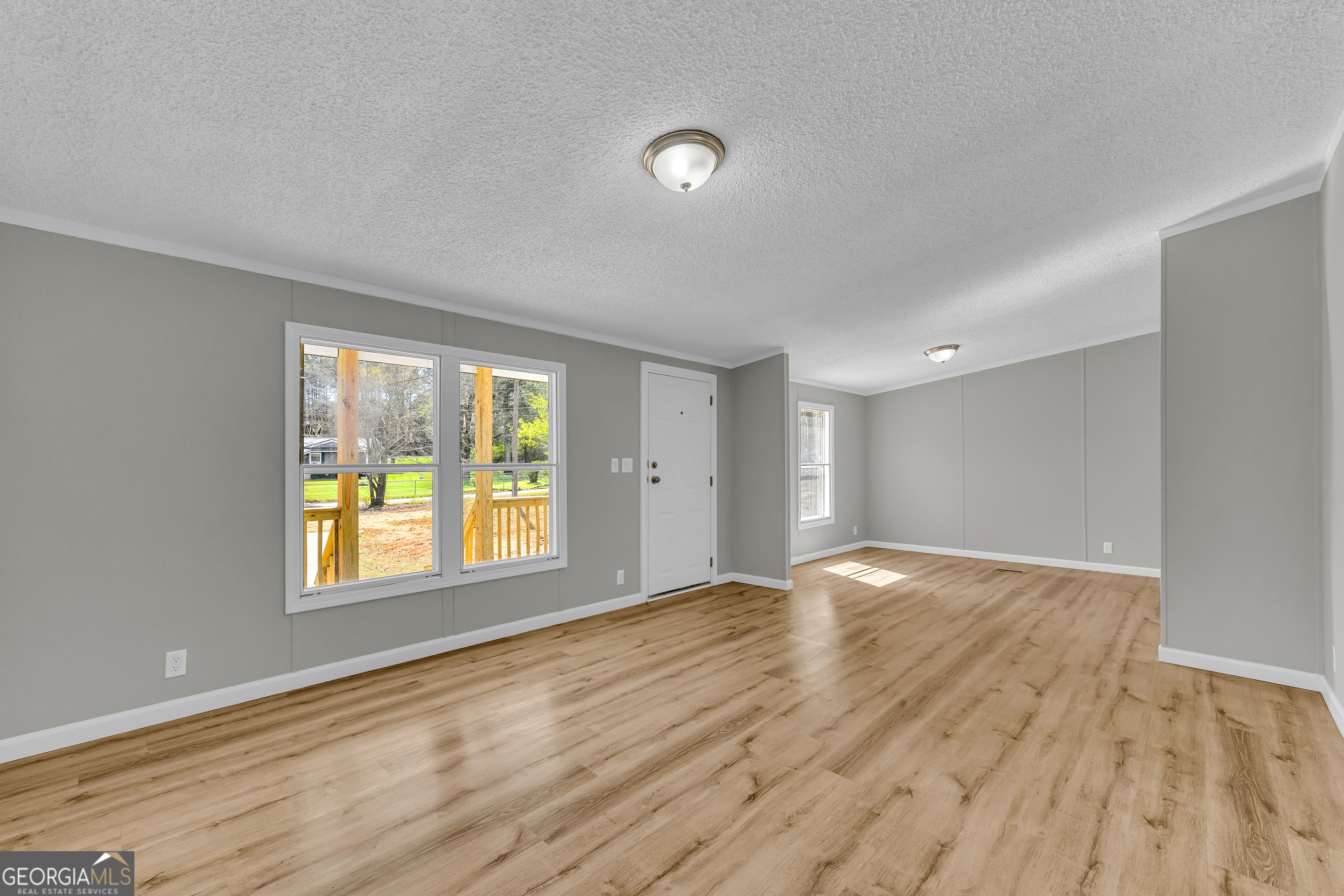 199 Alberta Drive Colbert, GA 30628 - Photo 11 of 39 a view of an empty room with wooden floor and a window