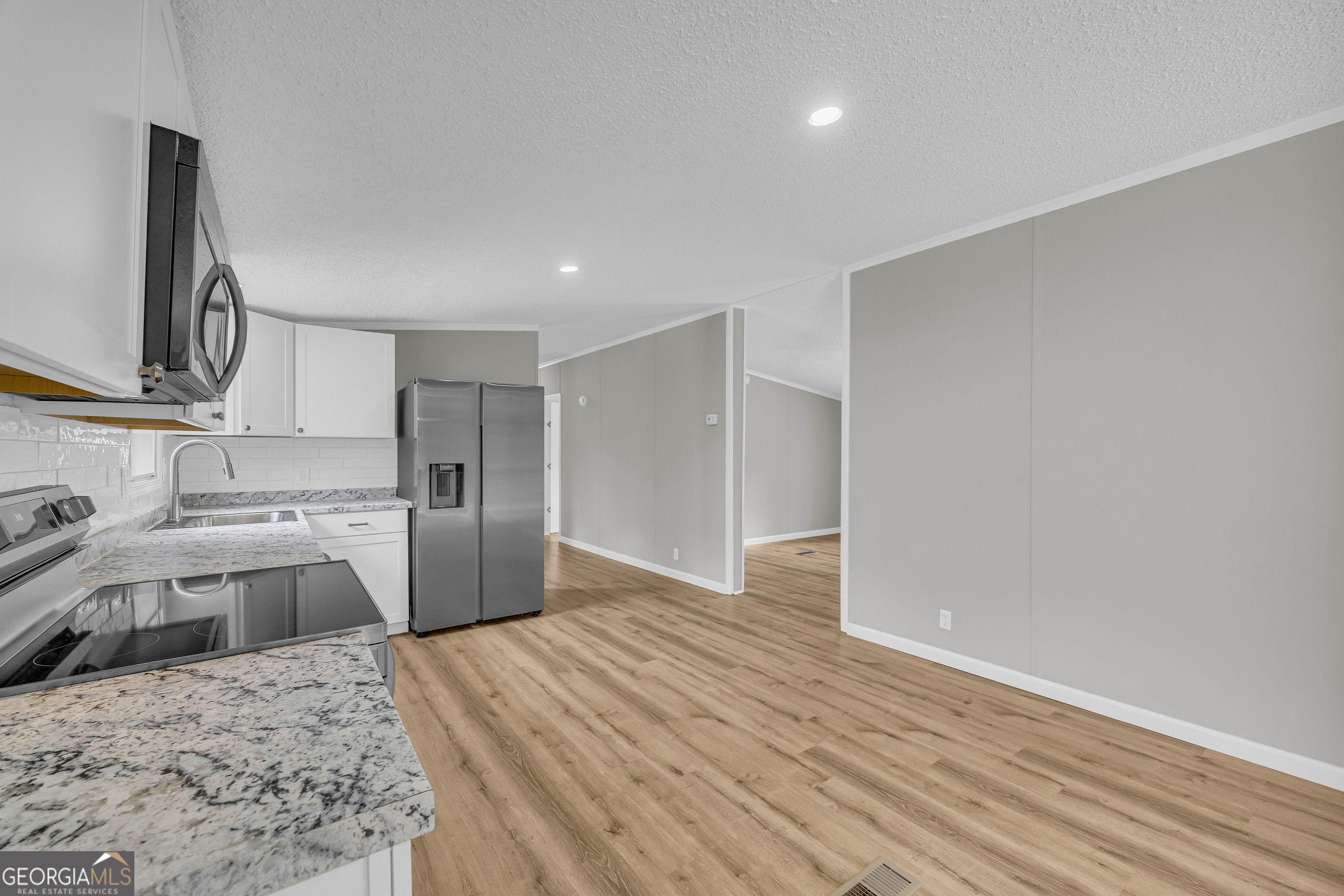 199 Alberta Drive Colbert, GA 30628 - Photo 16 of 39 a kitchen with a refrigerator sink and wooden floor