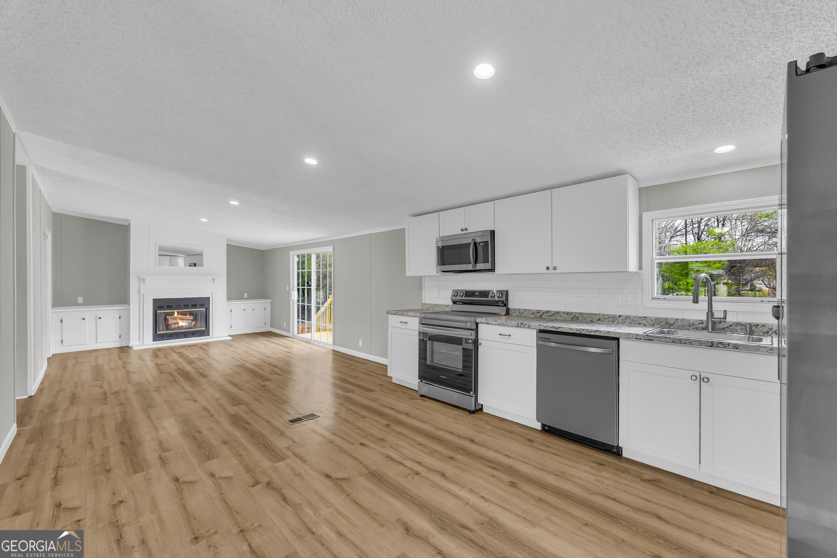 199 Alberta Drive Colbert, GA 30628 - Photo 17 of 39 a large kitchen with cabinets wooden floor and stainless steel appliances