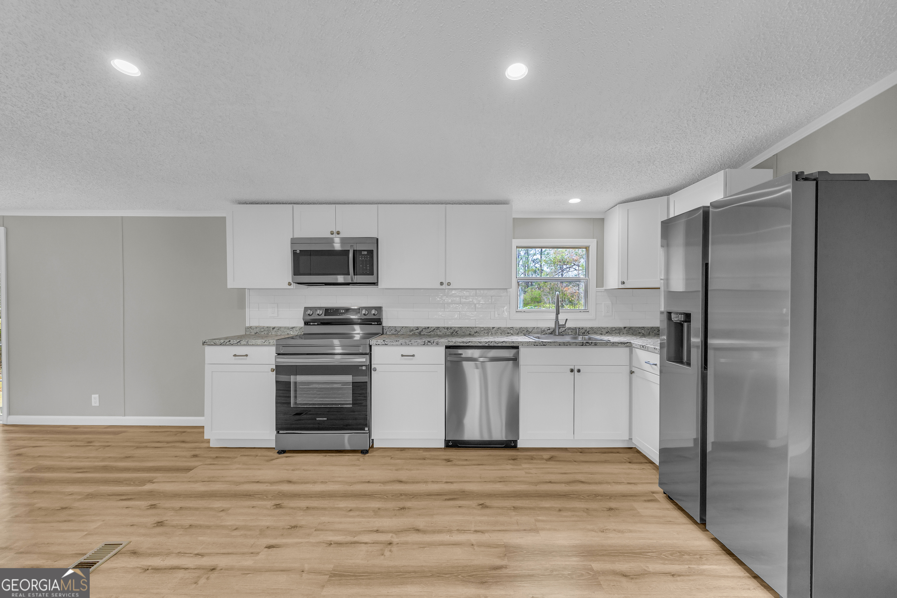 199 Alberta Drive Colbert, GA 30628 - Photo 18 of 39 a kitchen with granite countertop a refrigerator stove and oven