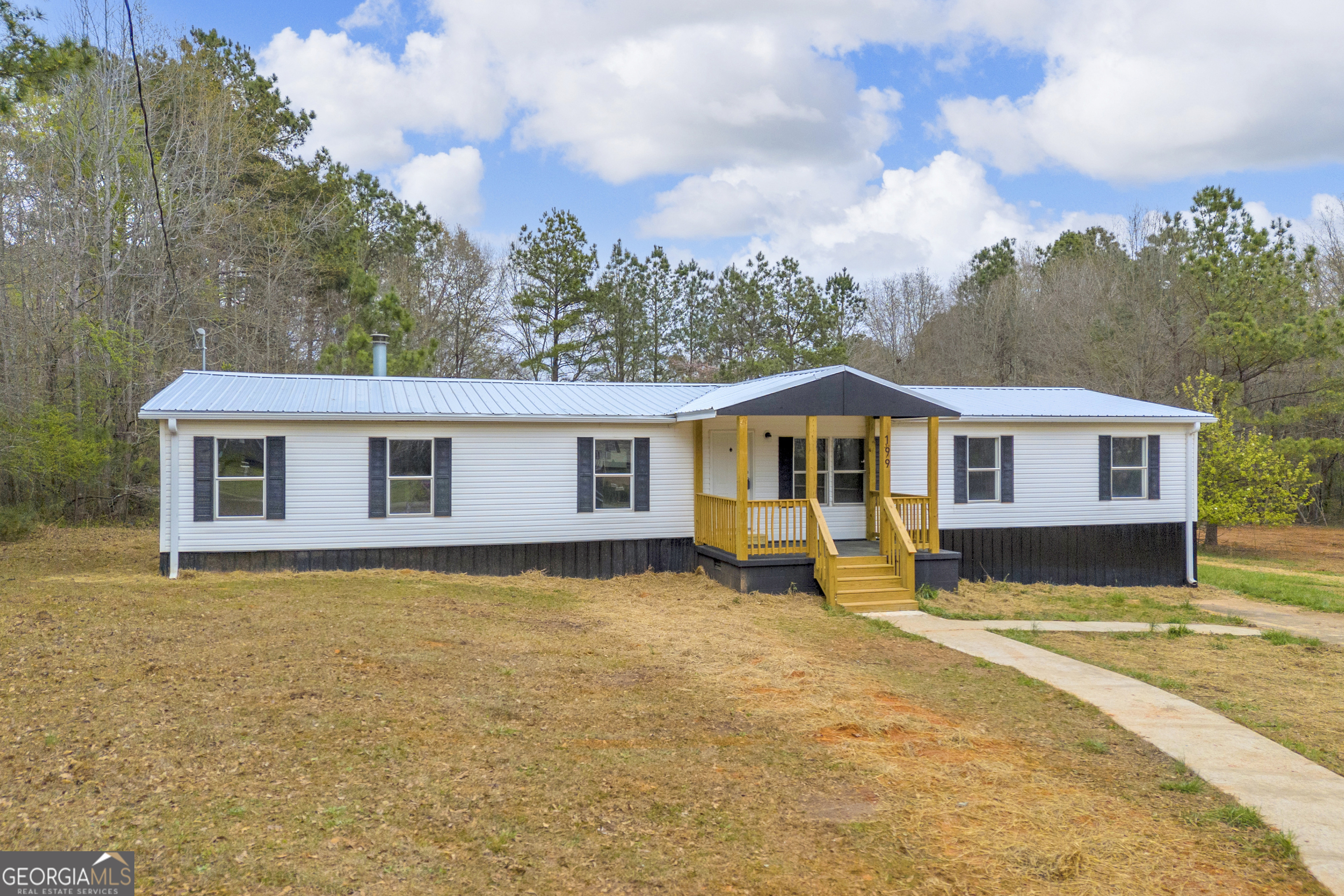 199 Alberta Drive Colbert, GA 30628 - Photo 2 of 39 a front view of a house with a yard table and chairs