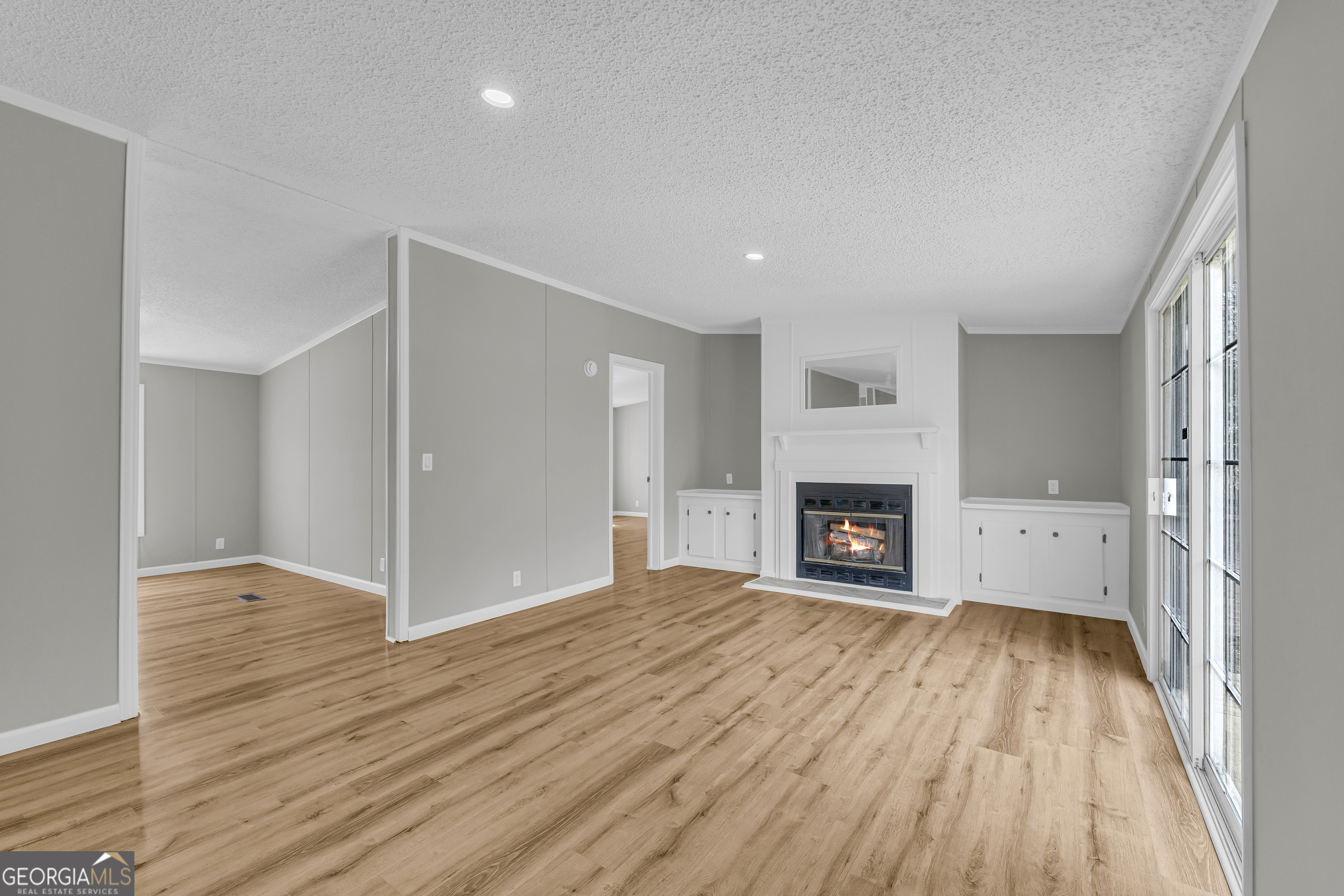 199 Alberta Drive Colbert, GA 30628 - Photo 21 of 39 an empty room with wooden floor fireplace and windows