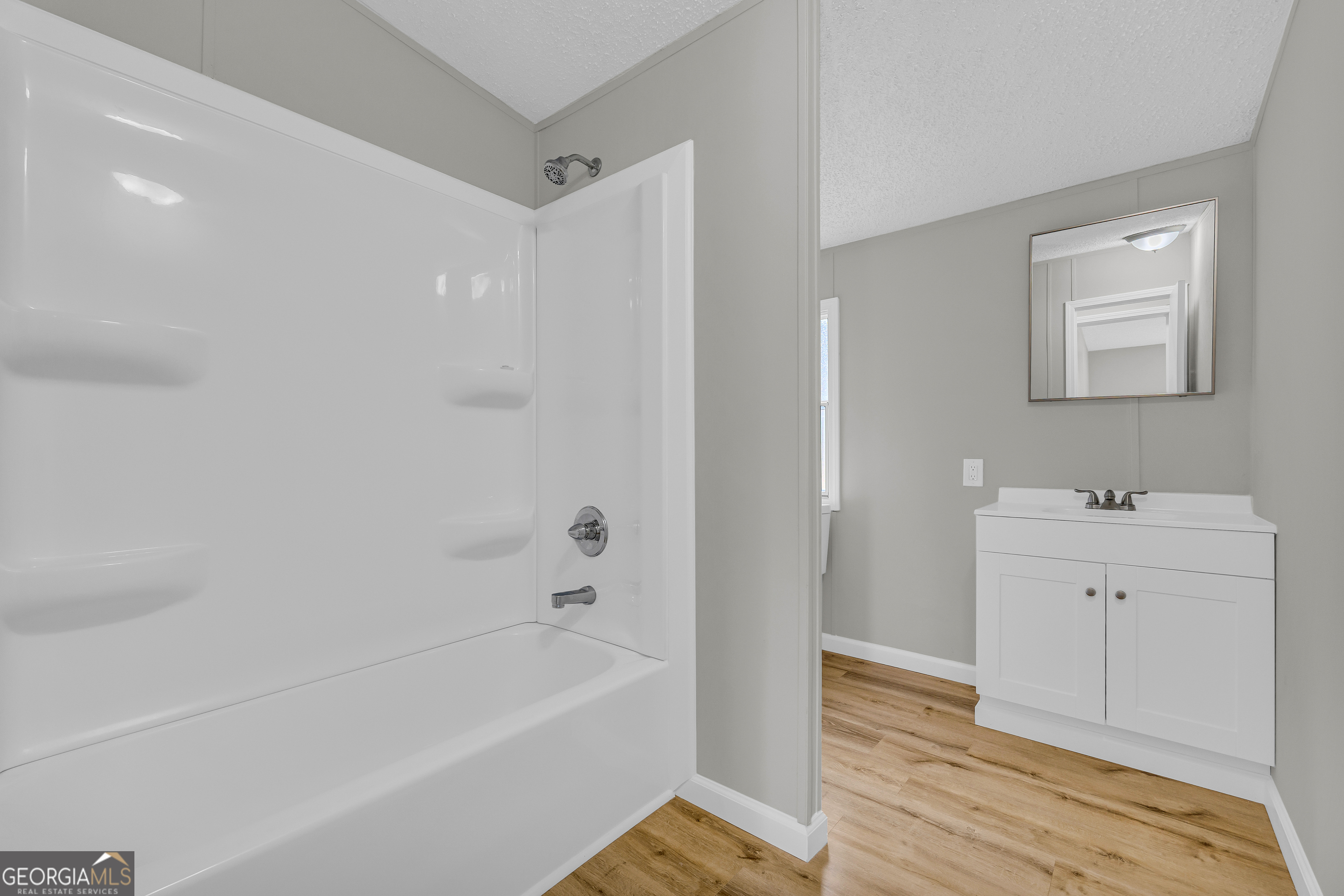 199 Alberta Drive Colbert, GA 30628 - Photo 28 of 39 a bathroom with a sink a mirror and a bathtub