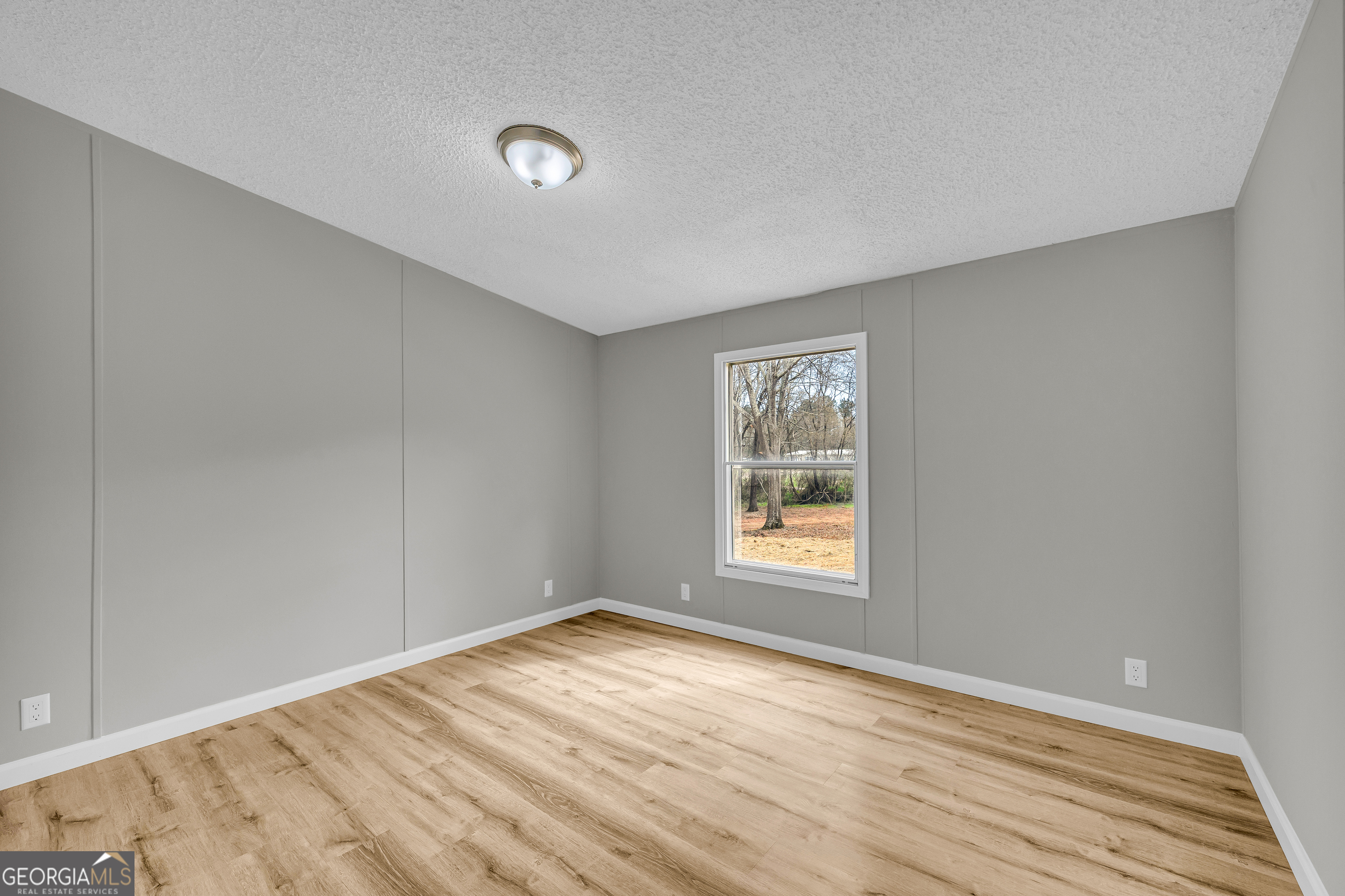 199 Alberta Drive Colbert, GA 30628 - Photo 31 of 39 a view of empty room with wooden floor and fan