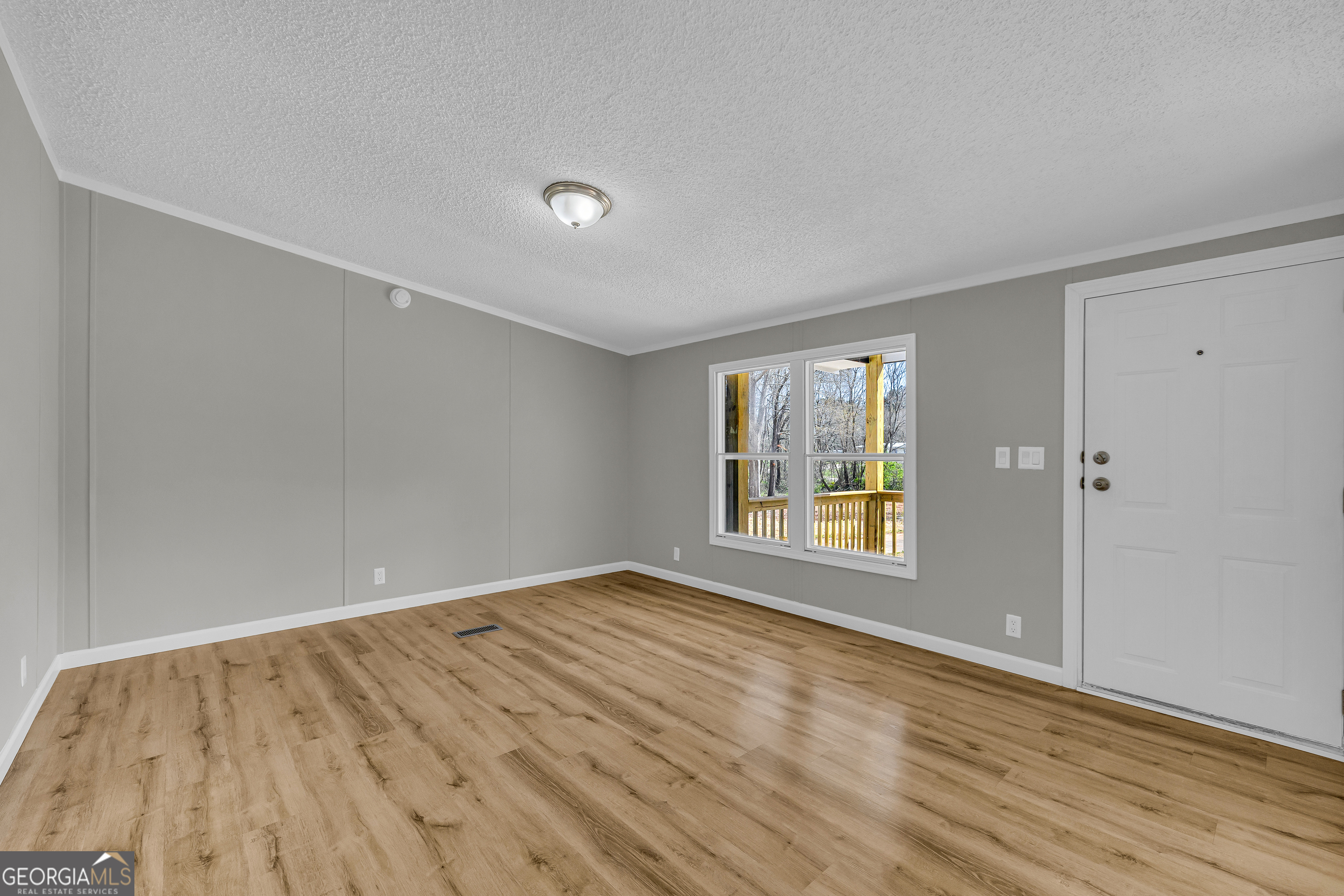 199 Alberta Drive Colbert, GA 30628 - Photo 10 of 39 a view of an empty room with wooden floor and a window
