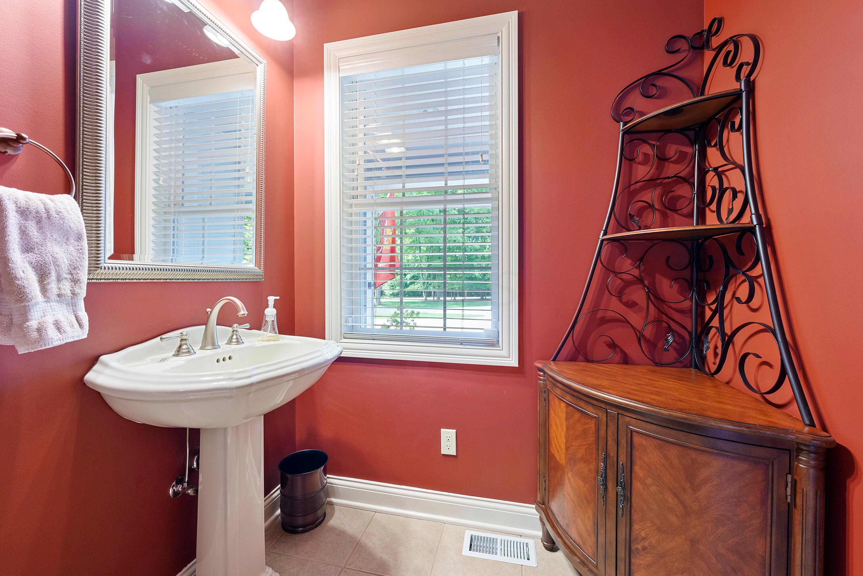 5761 Hughes Road Galena, OH 43021 - Photo 21 of 43 The Half Bath has ceramic tile flooring, a white pedestal sink, 10’ ceiling, and mirror with light bar.