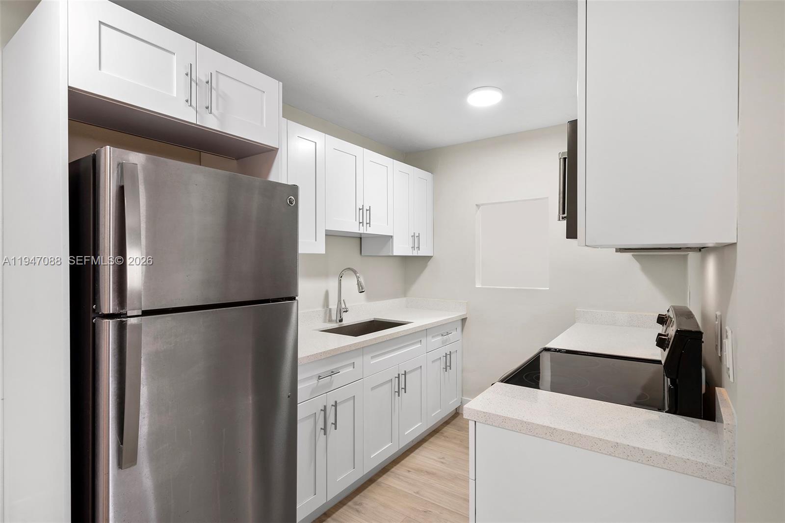 a kitchen with a refrigerator sink stove and cabinets