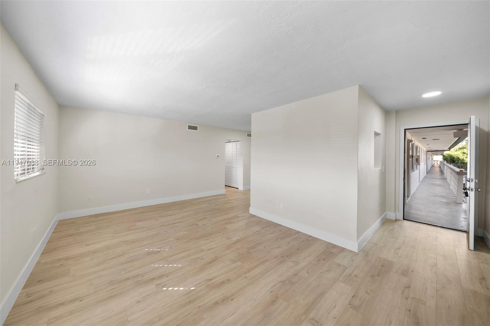 1330 West 29th Street, Unit 35 Hialeah, FL 33012 - Photo 4 of 16 an empty room with wooden floor and windows