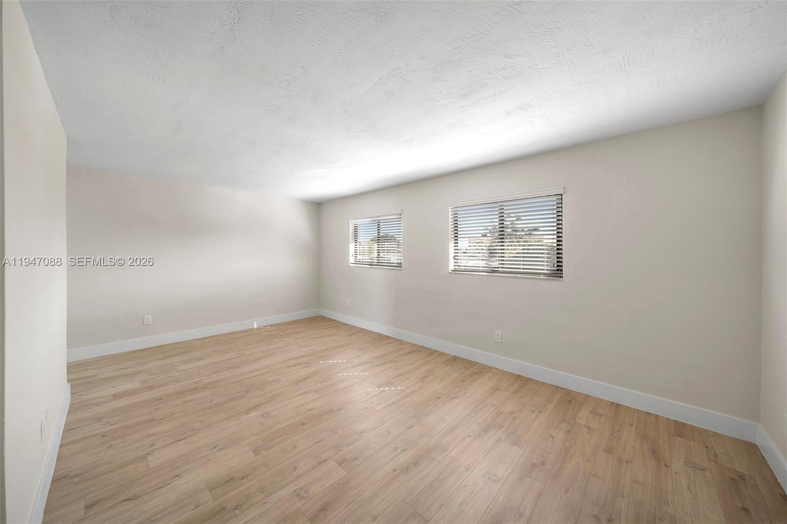 1330 West 29th Street, Unit 35 Hialeah, FL 33012 - Photo 8 of 16 an empty room with wooden floor and windows