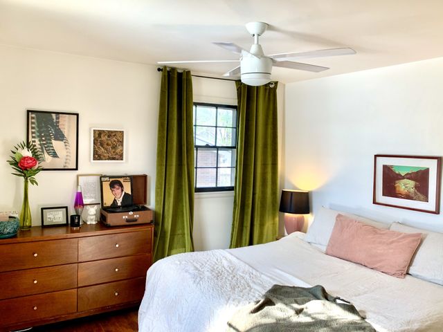 a bedroom with a bed and a mirror on dresser