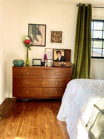 a bedroom with a bed and painting on the wall
