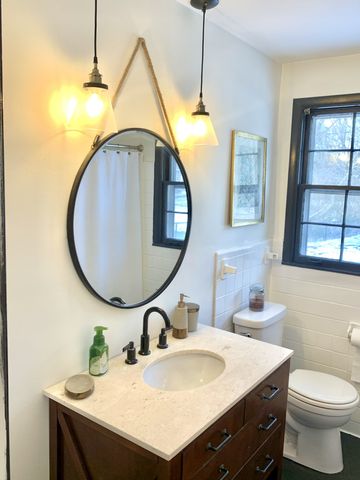 a bathroom with a sink a toilet and a mirror