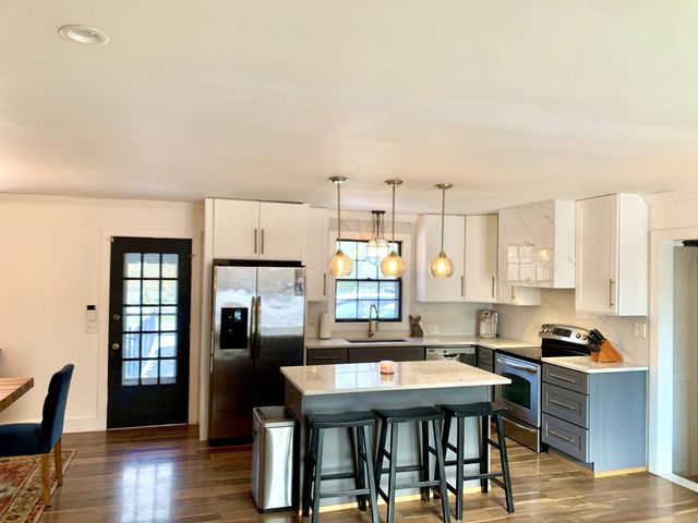 a kitchen with a table chairs refrigerator and cabinets
