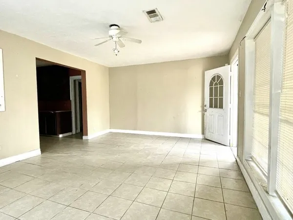 a view of an empty room with cabinet and a window