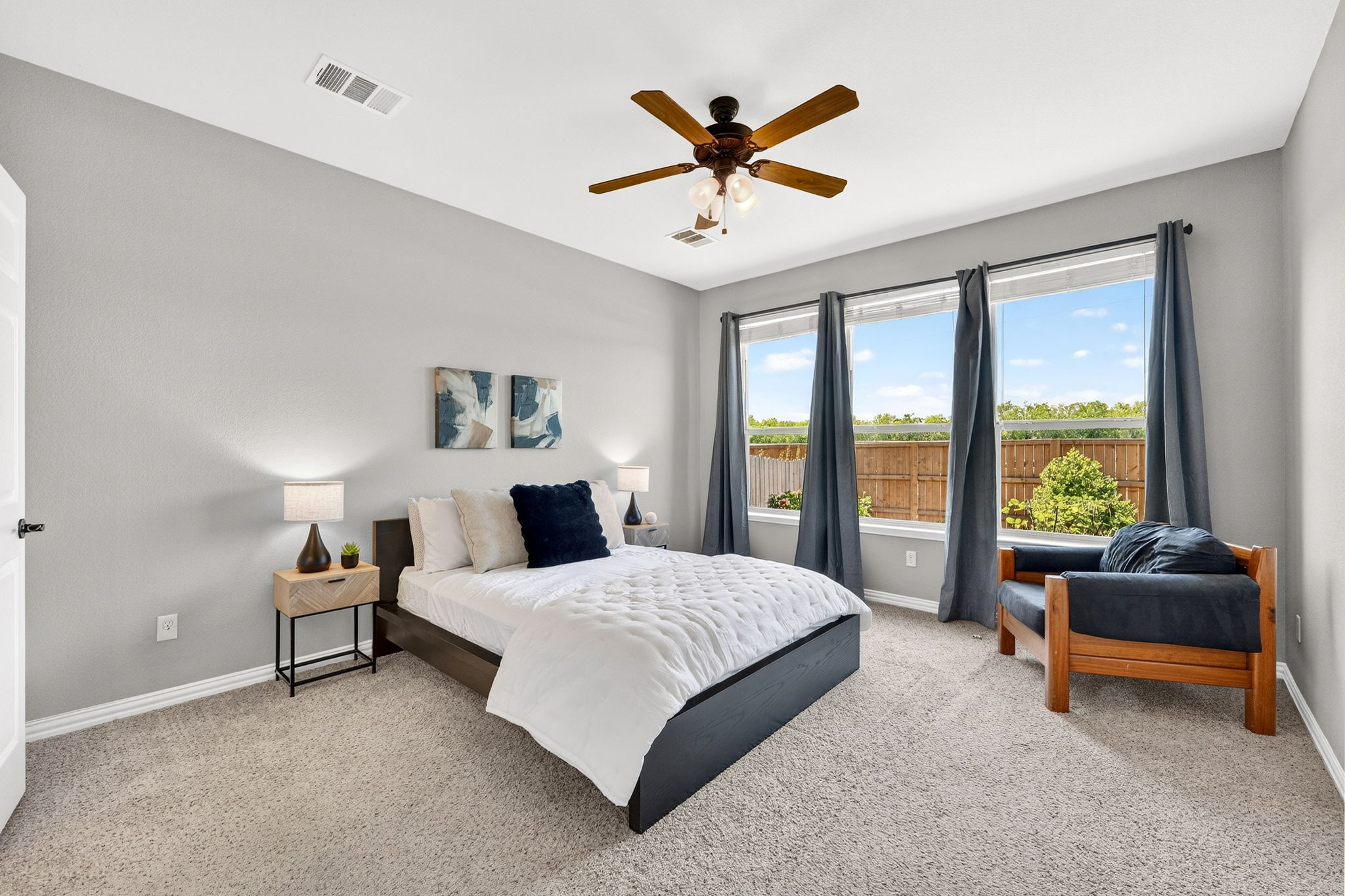 9932 Wading Pool Path Austin, TX 78748 - Photo 14 of 28 Escape to a primary suite that feels like a breath of fresh air. This suite features three oversized windows that overlook the greenery of the backyard.