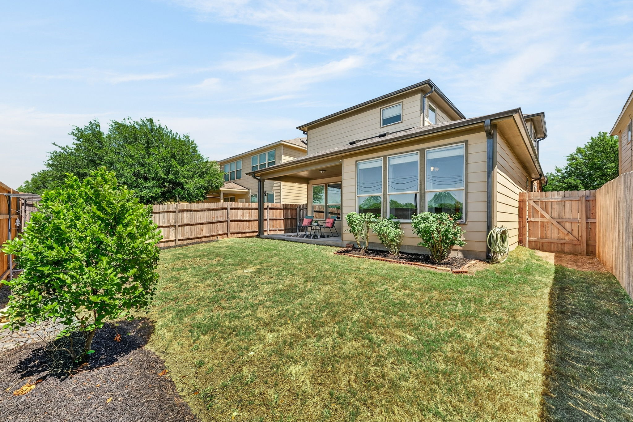 9932 Wading Pool Path Austin, TX 78748 - Photo 26 of 28 The meticulously maintained lawn is accented by young trees and a rose bush, creating a serene environment for pets to play or for you to start that garden you’ve always wanted.