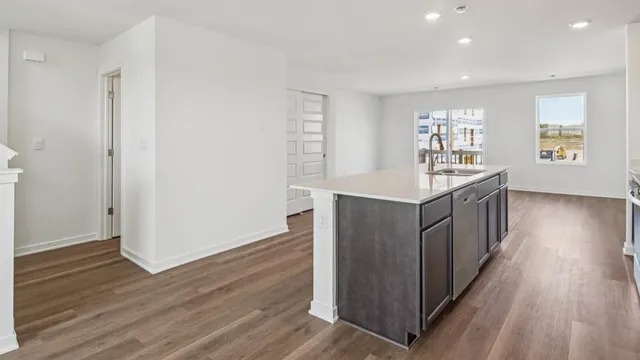 a kitchen with stainless steel appliances granite countertop a wooden cabinets a sink and wooden floor