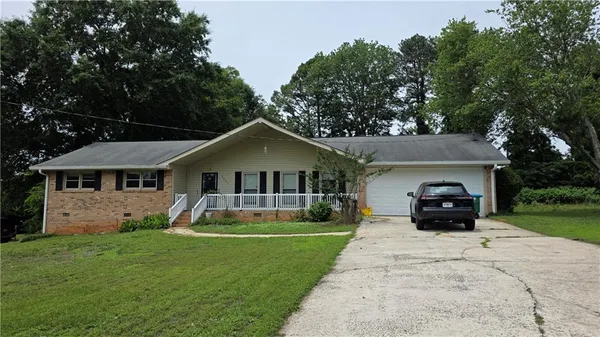 a front view of a house with a yard and green space