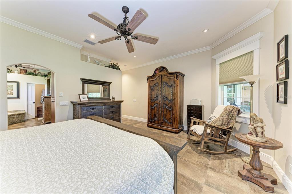 39321 Washington Loop Road Punta Gorda, FL 33982 - Photo 38 of 98 a bed room with a bed a flat screen tv and a chandelier