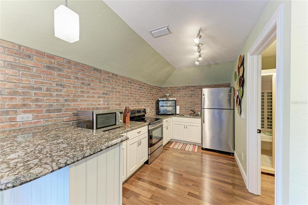 39321 Washington Loop Road Punta Gorda, FL 33982 - Photo 65 of 98 a kitchen with granite countertop a refrigerator oven a sink dishwasher and wooden floor