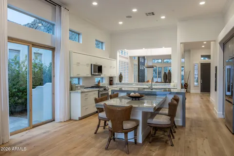 a kitchen with a dining table chairs and refrigerator