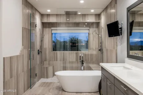 a bathroom with a tub sink a mirror and shower