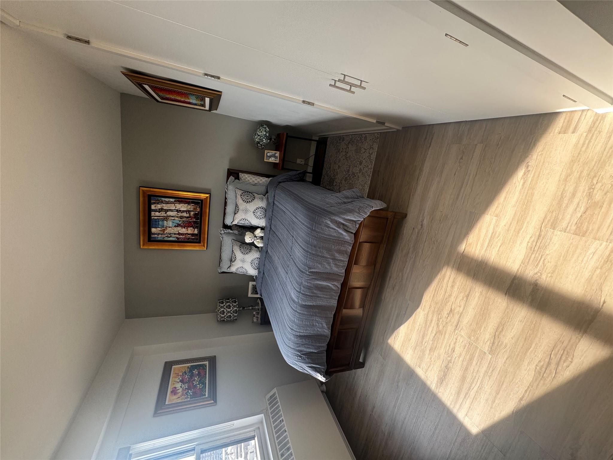 9 Fordham Hill Ovl, Unit 17C Bronx, NY 10468 - Photo 7 of 16 Bedroom featuring radiator heating unit and light hardwood / wood-style flooring