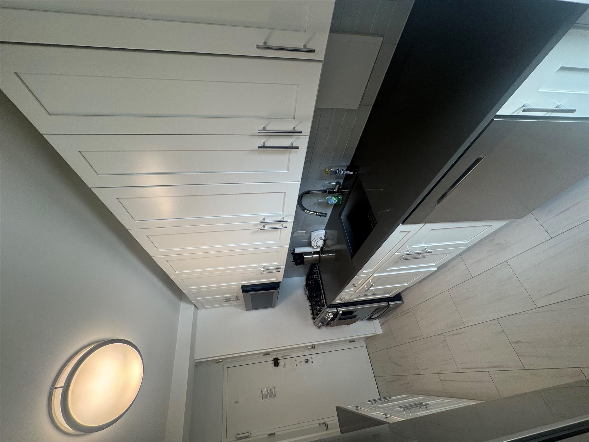 9 Fordham Hill Ovl, Unit 17C Bronx, NY 10468 - Photo 9 of 16 Kitchen with dishwashing machine, sink, white cabinets, and stove