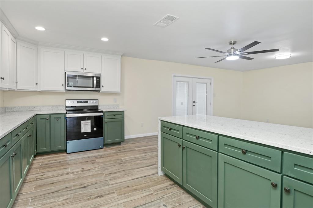 629 Edna Court Everman, TX 76140 - Photo 11 of 24 a kitchen with stainless steel appliances granite countertop a stove a sink and a refrigerator