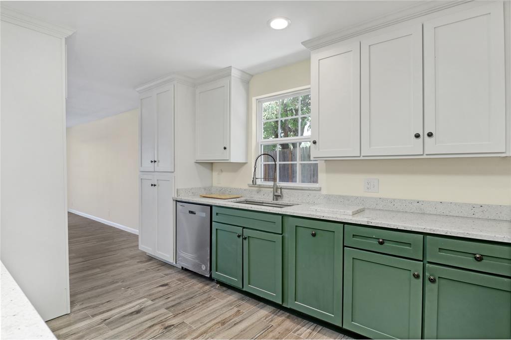 629 Edna Court Everman, TX 76140 - Photo 12 of 24 a kitchen with stainless steel appliances granite countertop a sink and cabinets with wooden floor