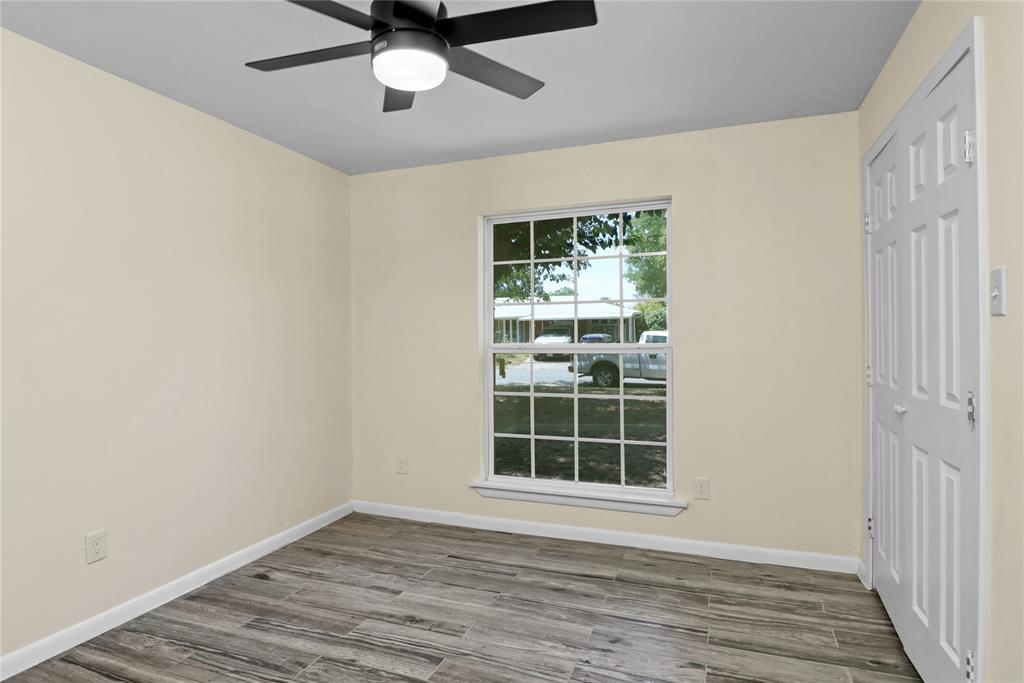 629 Edna Court Everman, TX 76140 - Photo 13 of 24 an empty room with wooden floor closet and windows
