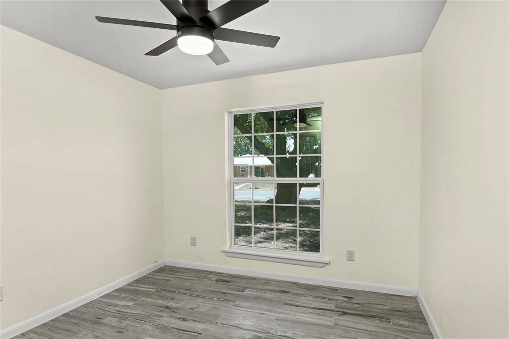 629 Edna Court Everman, TX 76140 - Photo 17 of 24 an empty room with wooden floor chandelier fan and windows