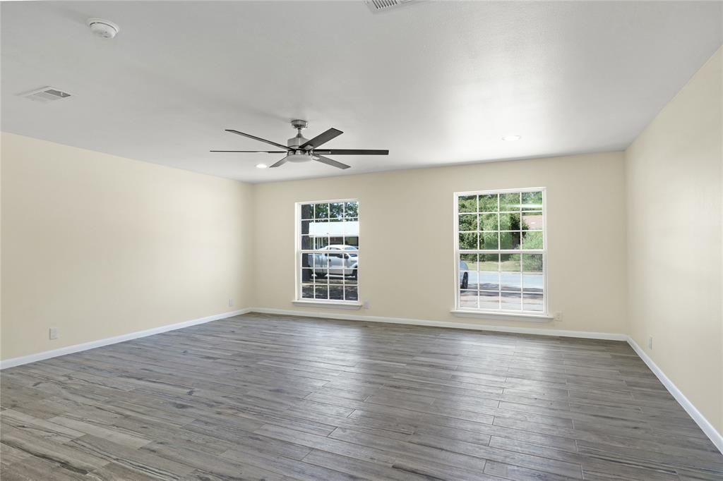 629 Edna Court Everman, TX 76140 - Photo 3 of 24 an empty room with wooden floor fan and windows