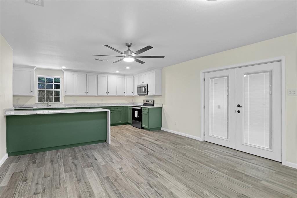 629 Edna Court Everman, TX 76140 - Photo 5 of 24 a kitchen with stainless steel appliances granite countertop a sink cabinets and a wooden floor