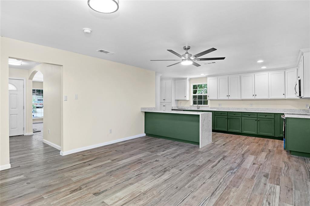 629 Edna Court Everman, TX 76140 - Photo 6 of 24 a kitchen with granite countertop a sink cabinets and wooden floor