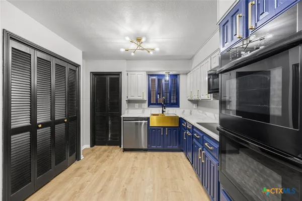 a large kitchen with stainless steel appliances granite countertop a refrigerator a oven a sink dishwasher and wooden cabinets