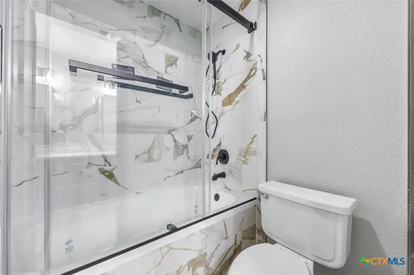 a white toilet sitting next to a bath tub shower
